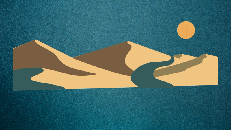 A desert road during nighttime with a striking deep blue background.